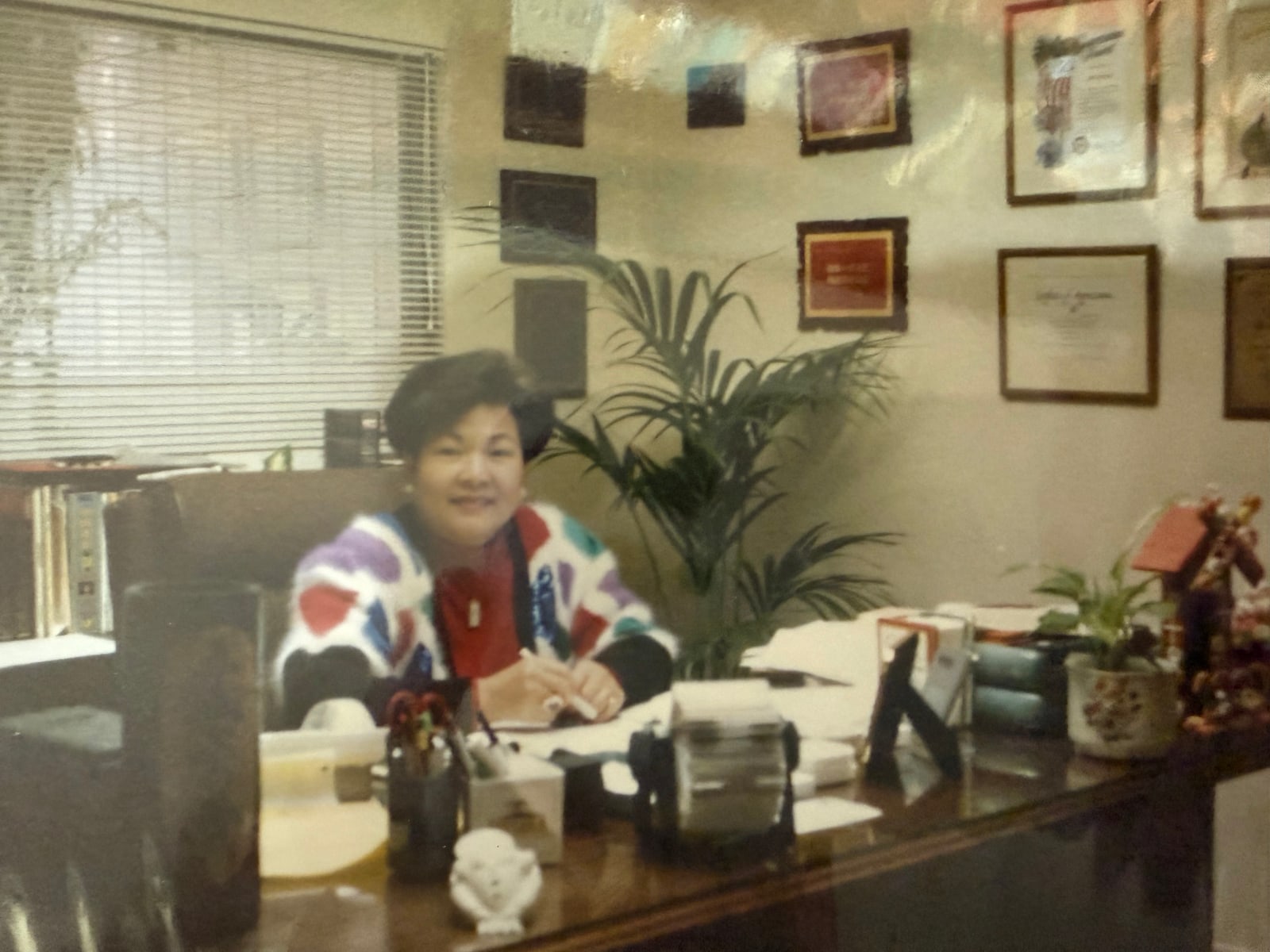 At her desk, awards on the wall